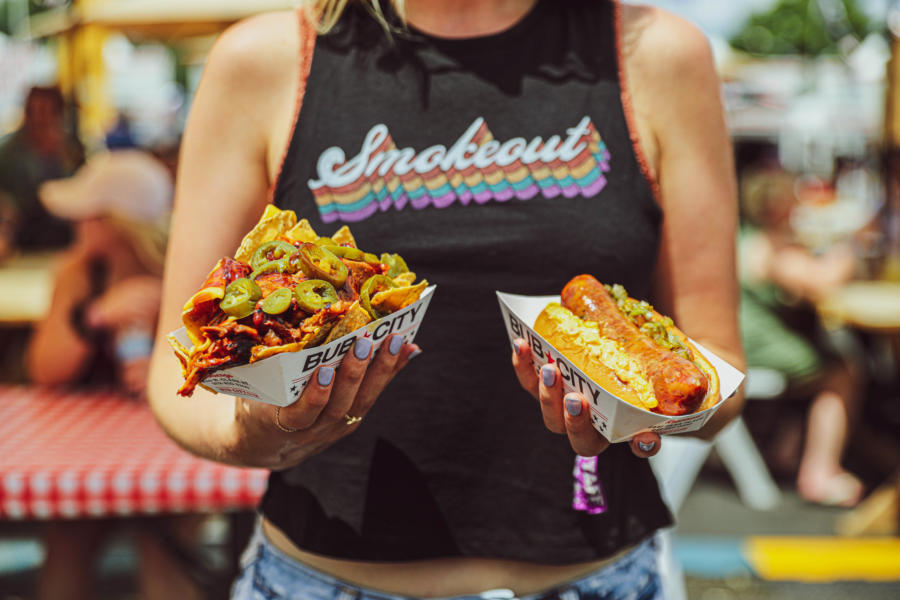 A woman holds BBQ dishes at Windy City Smokeout